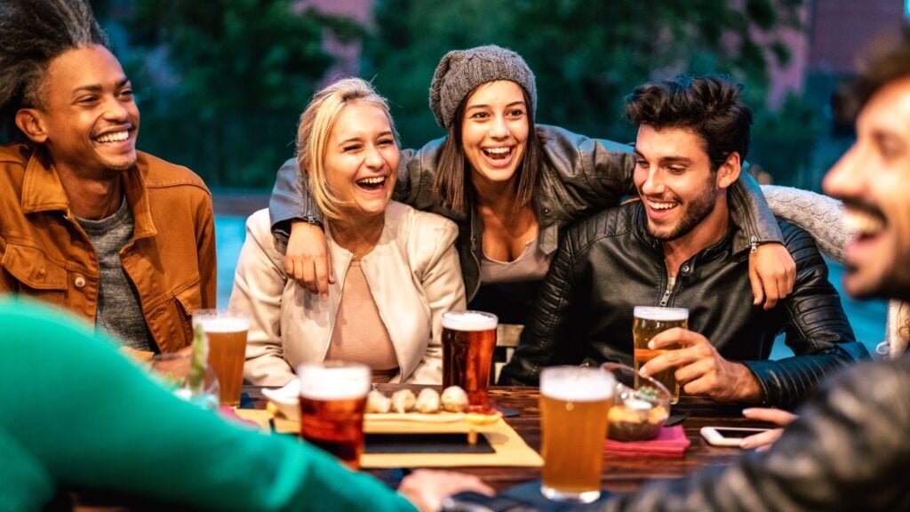 Friends-laughing-at-a-restaurant | MemberPress Amigos riendo en un restaurante